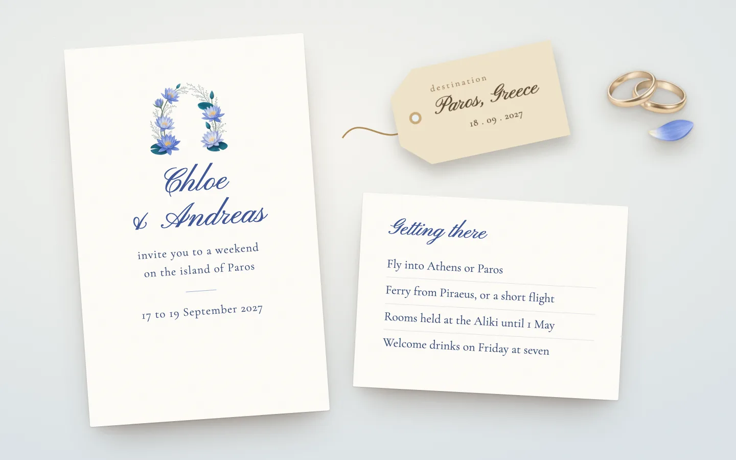 Chloe and Andreas's invitation to a weekend on Paros, with a luggage tag and a card on getting there: the flights, the ferry and where to stay, beside gold rings and a lily petal