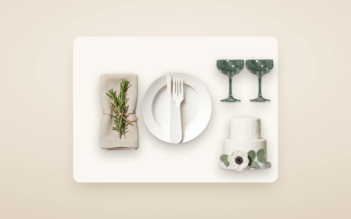 A wedding place setting: a white plate and folded linen napkin with rosemary, coupe glasses and a small white cake with anemones
